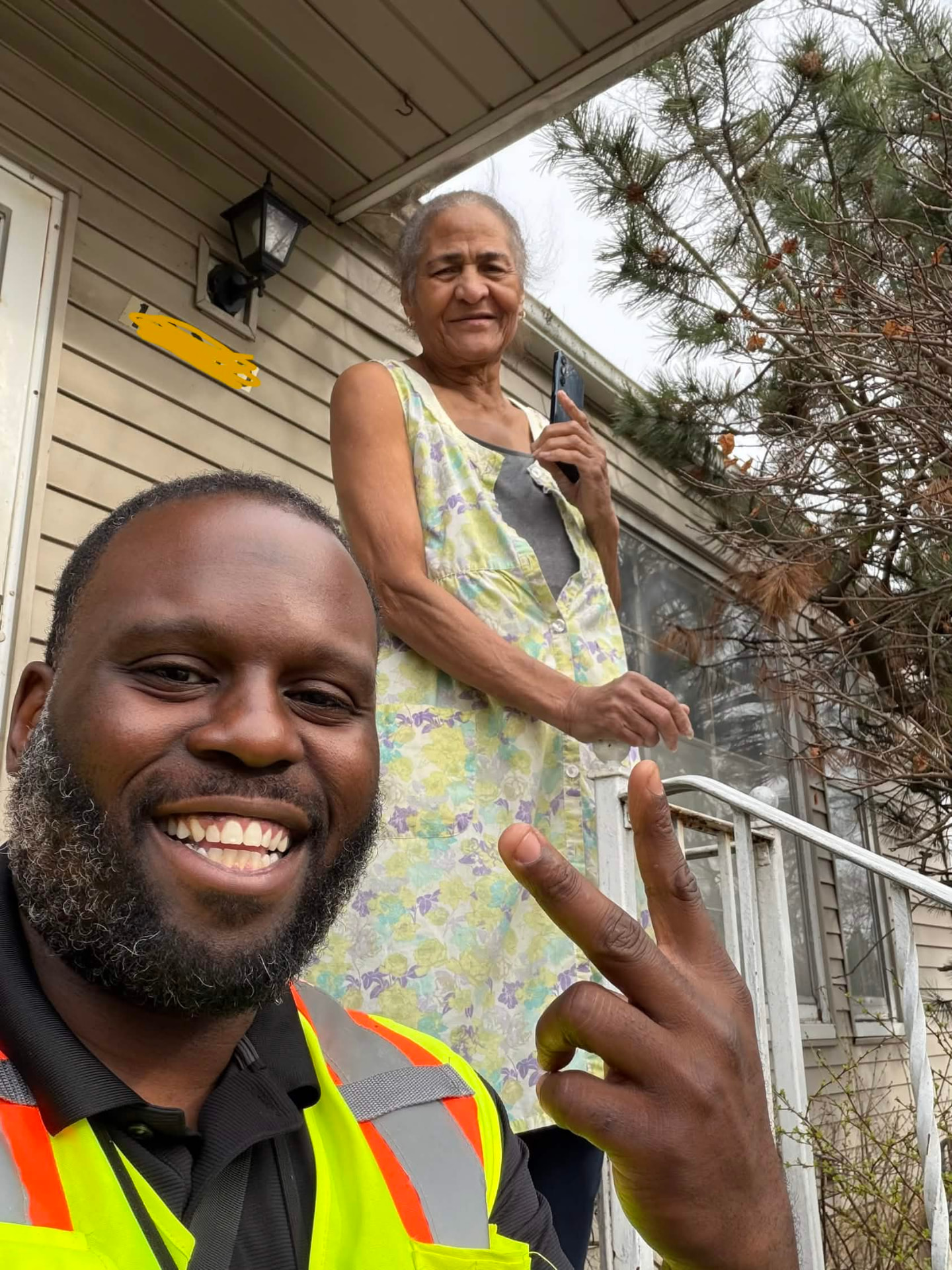 MIHSS technician taking a selfie with a smiling homeowner on her front porch